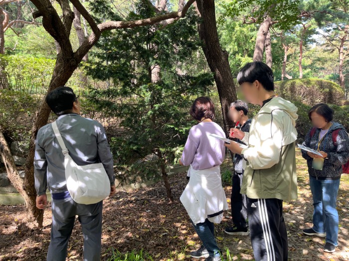 빙고판과 펜을 들고 빙고 속 나무를 찾음